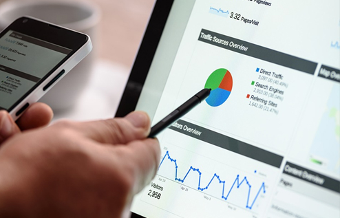 Sales person doing analysis in computer and mobile